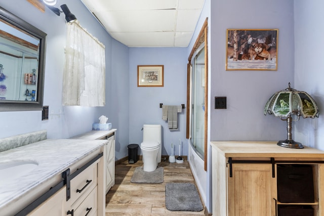 210 S Forbes St, Jackson, MI 49203 - bathroom with wood finished floors, vanity, and shower / bath combination with glass door