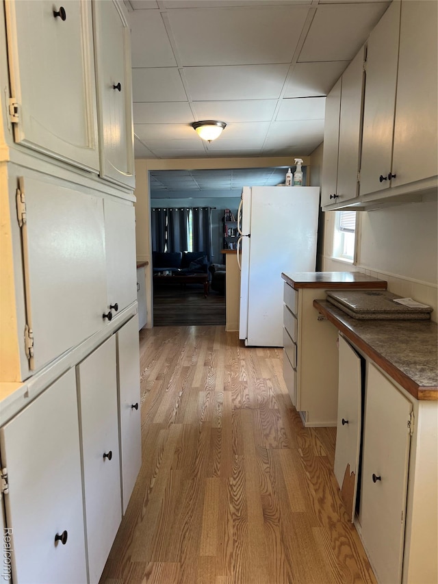 6860 Sheridan Rd, Saginaw, MI 48601 - kitchen featuring freestanding refrigerator, light wood-type flooring, dark countertops, and a paneled ceiling