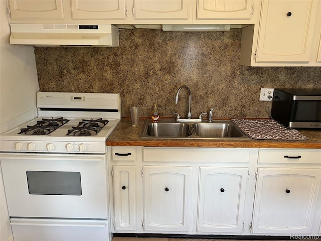 6860 Sheridan Rd, Saginaw, MI 48601 - kitchen featuring white gas stove, under cabinet range hood, stainless steel microwave, dark countertops, and tasteful backsplash