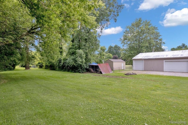 6516 Weyer Rd, Imlay City, MI 48444 - view of yard featuring an outdoor structure, a detached garage, a pole building, and an outdoor fire pit