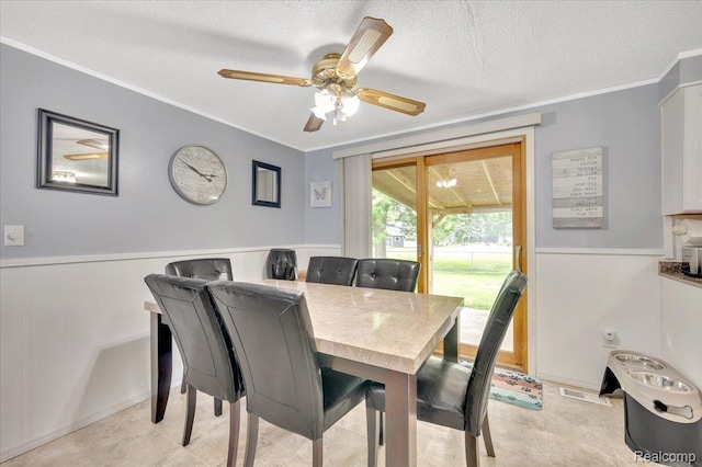 6516 Weyer Rd, Imlay City, MI 48444 - dining room with crown molding, wainscoting, a textured ceiling, and a ceiling fan