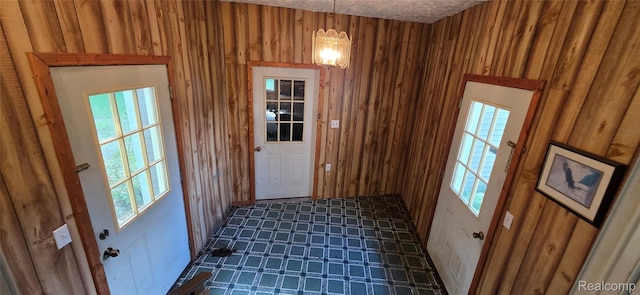 19270 W Brant Rd, Brant, MI 48614 - entryway with wood walls, a chandelier, and dark floors