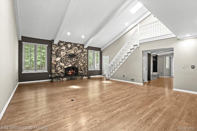 5152 Shenandoah Ct, West Bloomfield, MI 48323 - unfurnished living room with stairway, a fireplace, wood finished floors, a textured ceiling, and beam ceiling