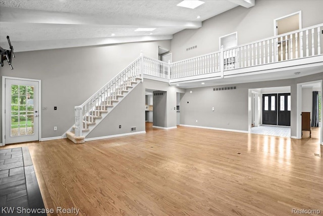 5152 Shenandoah Ct, West Bloomfield, MI 48323 - unfurnished living room featuring high vaulted ceiling, stairs, wood finished floors, and beam ceiling