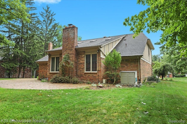 5152 Shenandoah Ct, West Bloomfield, MI 48323 - back of house featuring board and batten siding, a chimney, a lawn, brick siding, and roof with shingles