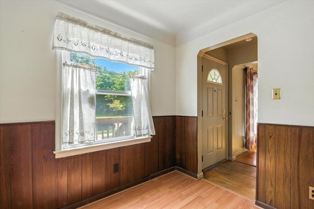 2251 Gardner Ave, Berkley, MI 48072 - entrance foyer featuring a wainscoted wall, wooden walls, light wood-type flooring, and arched walkways