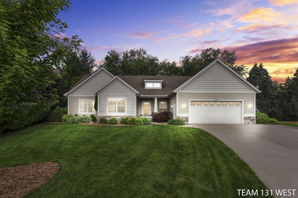 10778 Bridgewater Dr, Zeeland, MI 49464 - view of front facade featuring stone siding, concrete driveway, an attached garage, a yard, and roof with shingles