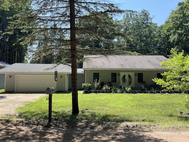 2564 Bialik Rd, Manistee, MI 49660 - single story home featuring dirt driveway, an attached garage, a front lawn, and a shingled roof