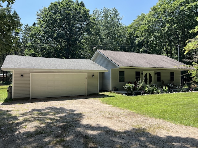 2564 Bialik Rd, Manistee, MI 49660 - ranch-style house with dirt driveway, a front lawn, and a garage