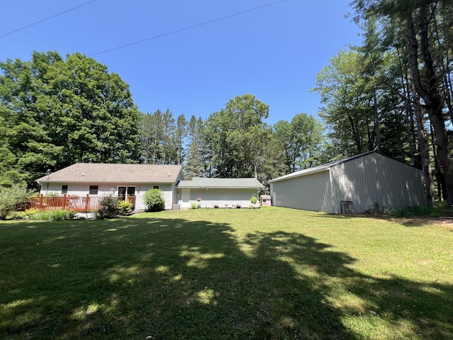 2564 Bialik Rd, Manistee, MI 49660 - view of green lawn with a wooden deck and an outdoor structure
