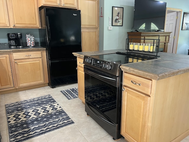 2564 Bialik Rd, Manistee, MI 49660 - kitchen with black appliances, light brown cabinetry, light tile patterned flooring, and tile counters
