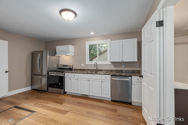 911 Baldwin St SE, Grand Rapids, MI 49506 - kitchen featuring appliances with stainless steel finishes, under cabinet range hood, white cabinets, and light wood-type flooring