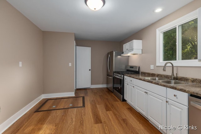 911 Baldwin St SE, Grand Rapids, MI 49506 - kitchen featuring stainless steel appliances, under cabinet range hood, wood finished floors, dark countertops, and recessed lighting