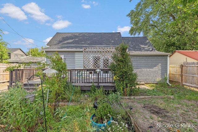 911 Baldwin St SE, Grand Rapids, MI 49506 - back of house featuring a deck, a shingled roof, and a garden