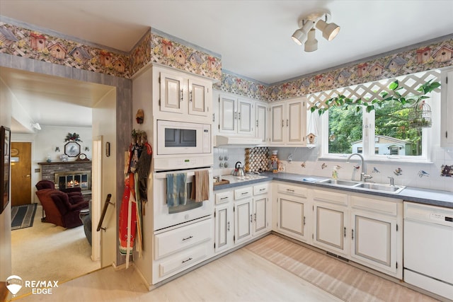 11206 E Atherton Rd, Davison, MI 48423 - kitchen with white appliances, backsplash, a fireplace, and light wood-style flooring