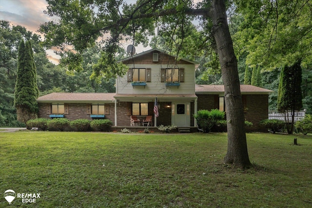 11206 E Atherton Rd, Davison, MI 48423 - view of front of home with covered porch, a front lawn, and brick siding