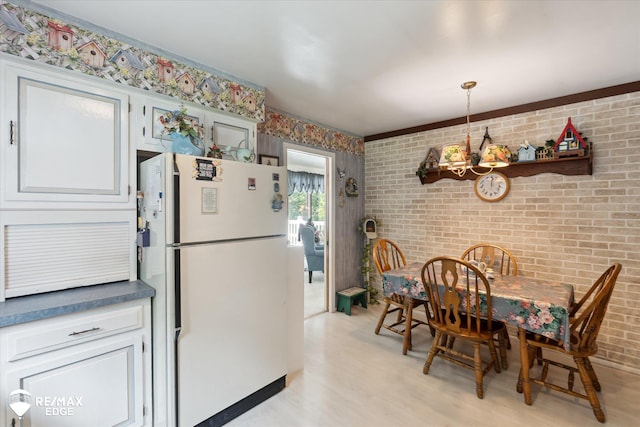 11206 E Atherton Rd, Davison, MI 48423 - dining room featuring a chandelier, brick wall, and light wood-type flooring