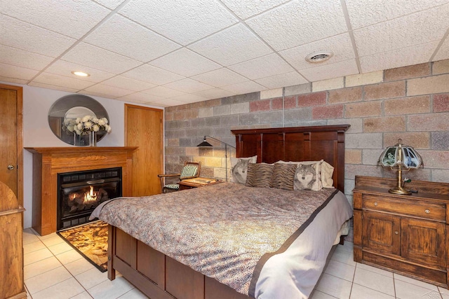 5370 N Lake Sanford Rd, Sanford, MI 48657 - bedroom with a glass covered fireplace, light tile patterned flooring, and a drop ceiling