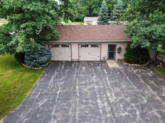 5370 N Lake Sanford Rd, Sanford, MI 48657 - view of front of home with an attached garage, asphalt driveway, a front lawn, and roof with shingles