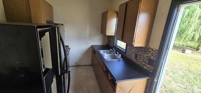 4997 S Croton Hardy Dr, Newaygo, MI 49337 - kitchen with freestanding refrigerator, decorative backsplash, brown cabinetry, and dark countertops