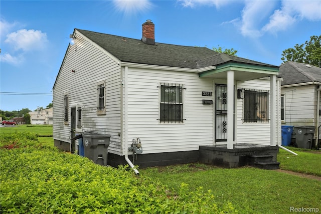 3887 Moore Ave, Allen Park, MI 48141 - back of property with a lawn, a chimney, and a shingled roof