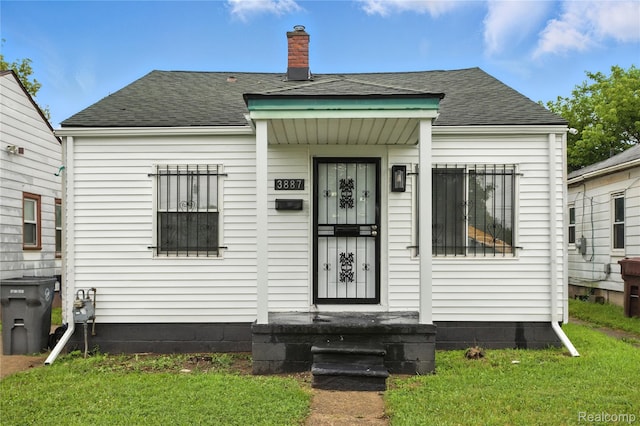 3887 Moore Ave, Allen Park, MI 48141 - bungalow-style home featuring roof with shingles, a chimney, and a front lawn