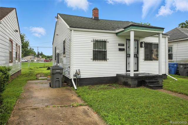 3887 Moore Ave, Allen Park, MI 48141 - view of front of property with a chimney, a front lawn, and a shingled roof