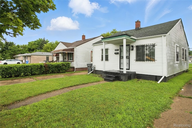 3887 Moore Ave, Allen Park, MI 48141 - view of front facade with a front yard, a chimney, and a shingled roof