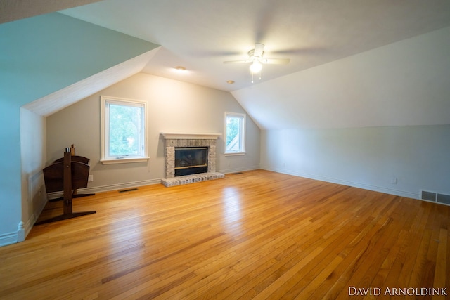 401 Erin Isle Ct, Holland, MI 49424 - unfurnished living room with a ceiling fan, light wood-style flooring, vaulted ceiling, and a fireplace