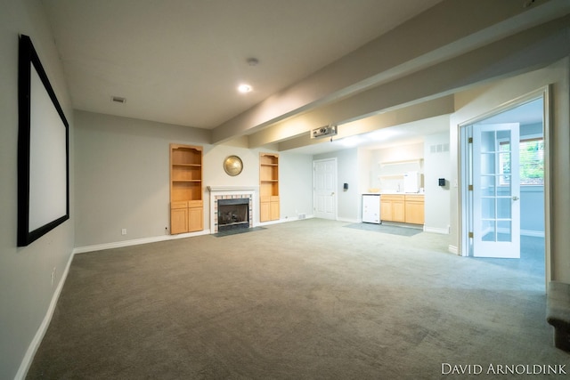 401 Erin Isle Ct, Holland, MI 49424 - unfurnished living room with carpet flooring, a tile fireplace, built in shelves, and beam ceiling