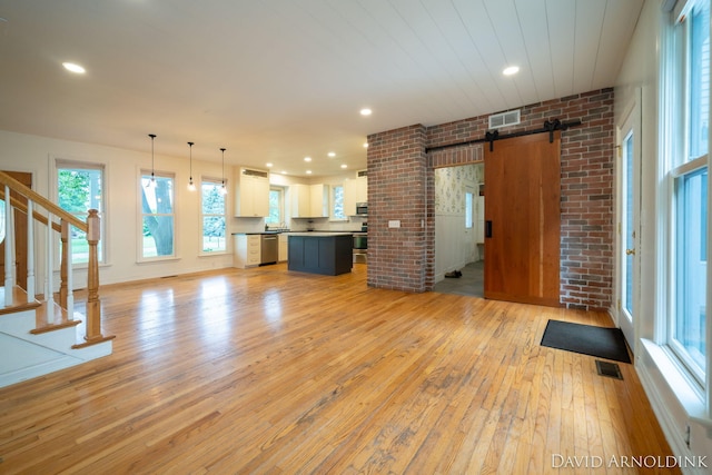 401 Erin Isle Ct, Holland, MI 49424 - unfurnished living room featuring a barn door, light wood finished floors, stairs, and recessed lighting