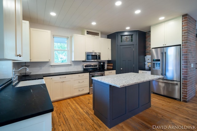 401 Erin Isle Ct, Holland, MI 49424 - kitchen featuring stainless steel appliances, backsplash, wood finished floors, a kitchen island, and recessed lighting