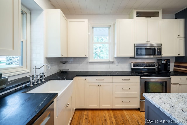 401 Erin Isle Ct, Holland, MI 49424 - kitchen with stainless steel appliances, light wood-type flooring, decorative backsplash, white cabinets, and wooden ceiling