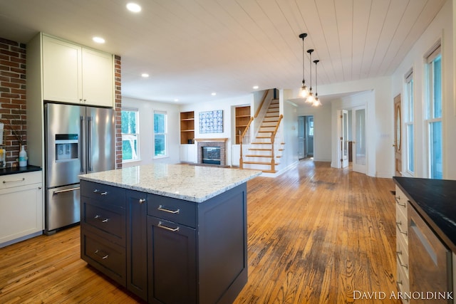 401 Erin Isle Ct, Holland, MI 49424 - kitchen featuring high quality fridge, a brick fireplace, wood-type flooring, white cabinets, and recessed lighting