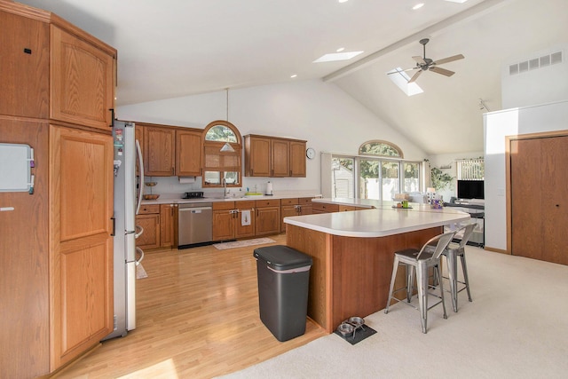 10850 Rajah Dr, Zeeland, MI 49464 - kitchen featuring dishwasher, high vaulted ceiling, a skylight, a kitchen bar, and light countertops
