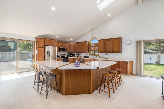 10850 Rajah Dr, Zeeland, MI 49464 - kitchen with appliances with stainless steel finishes, light colored carpet, high vaulted ceiling, light countertops, and a large island