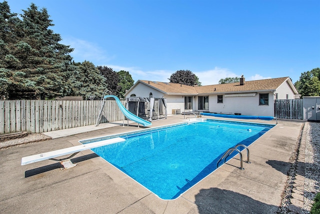 10850 Rajah Dr, Zeeland, MI 49464 - view of pool featuring a diving board, a water slide, a patio area, and a fenced backyard