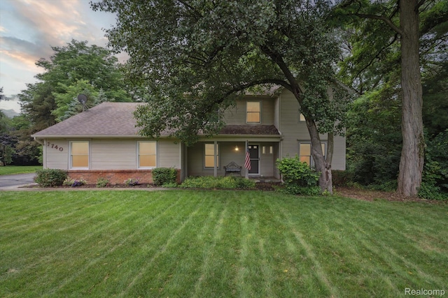 7740 Athlone Dr, Brighton, MI 48116 - view of front of home with a front yard, a porch, and brick siding