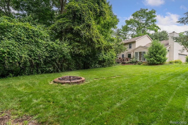 7740 Athlone Dr, Brighton, MI 48116 - view of green lawn featuring an outdoor fire pit and a deck