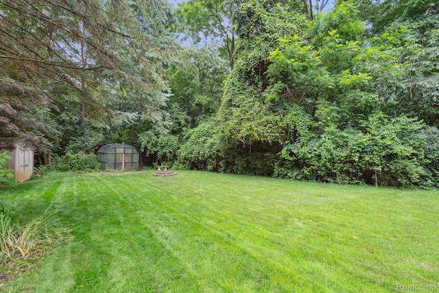 7740 Athlone Dr, Brighton, MI 48116 - view of grassy yard featuring an outdoor structure and a greenhouse