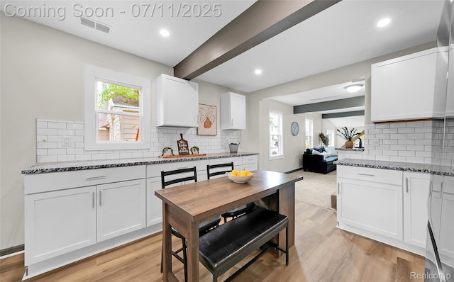 313 W Harwood Ave, Madison Heights, MI 48071 - kitchen featuring decorative backsplash, dark stone countertops, white cabinets, light wood-type flooring, and recessed lighting