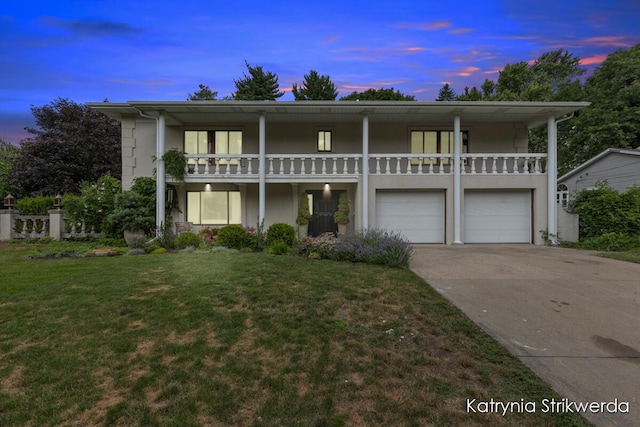 1217 El Camino Dr NW, Grand Rapids, MI 49504 - view of front facade with a balcony, stucco siding, concrete driveway, a front lawn, and an attached garage