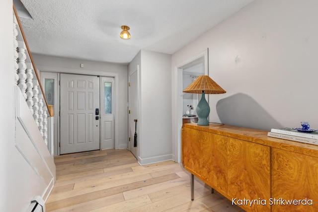 1217 El Camino Dr NW, Grand Rapids, MI 49504 - foyer entrance featuring light wood-type flooring, baseboard heating, and a textured ceiling
