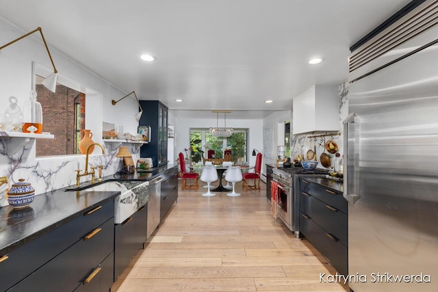 1217 El Camino Dr NW, Grand Rapids, MI 49504 - kitchen featuring high end appliances, light wood finished floors, dark countertops, recessed lighting, and backsplash