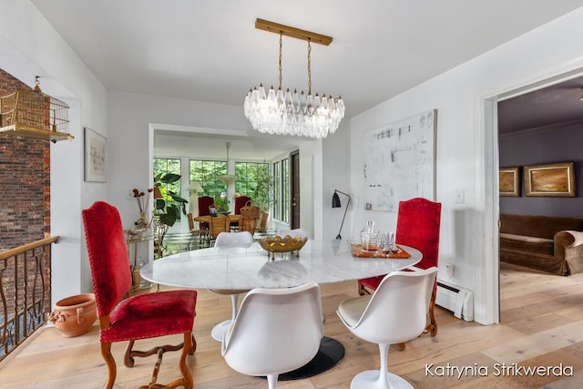 1217 El Camino Dr NW, Grand Rapids, MI 49504 - dining room featuring wood finished floors, a baseboard radiator, and a chandelier