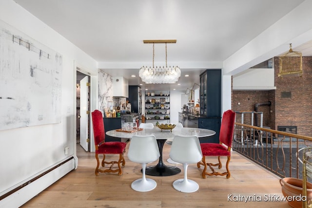 1217 El Camino Dr NW, Grand Rapids, MI 49504 - dining room featuring baseboard heating, wood finished floors, and a chandelier