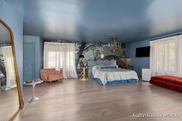 1217 El Camino Dr NW, Grand Rapids, MI 49504 - bedroom featuring wood finished floors and a chandelier