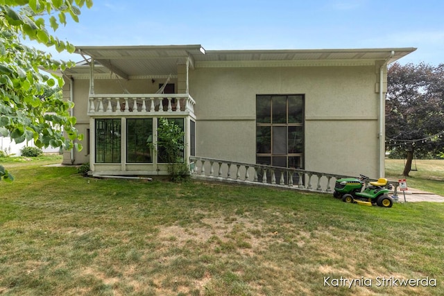 1217 El Camino Dr NW, Grand Rapids, MI 49504 - rear view of property featuring a lawn, stucco siding, and a balcony