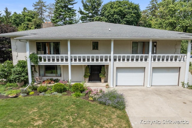 1217 El Camino Dr NW, Grand Rapids, MI 49504 - view of front of house with an attached garage, driveway, a balcony, a chimney, and stucco siding