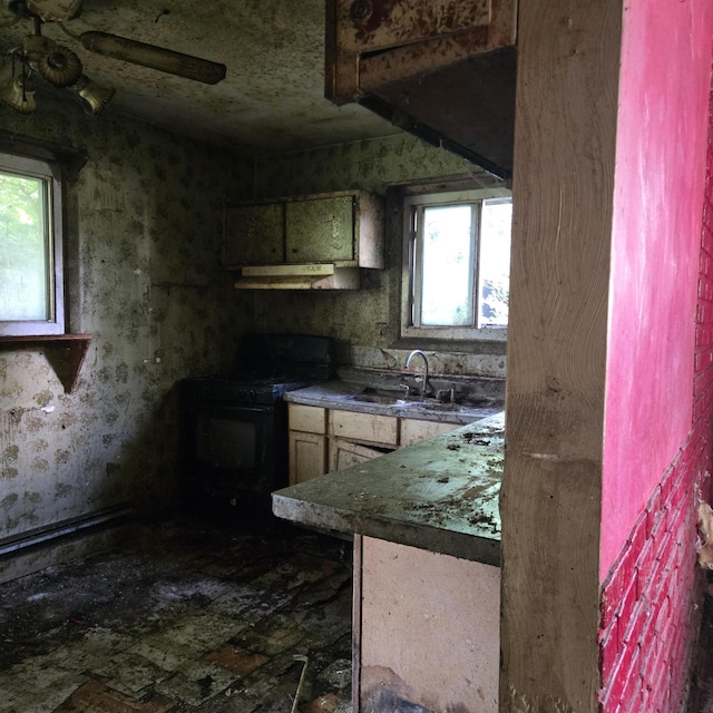 709 11th St, Three Rivers, MI 49093 - kitchen featuring gas stove, under cabinet range hood, and plenty of natural light